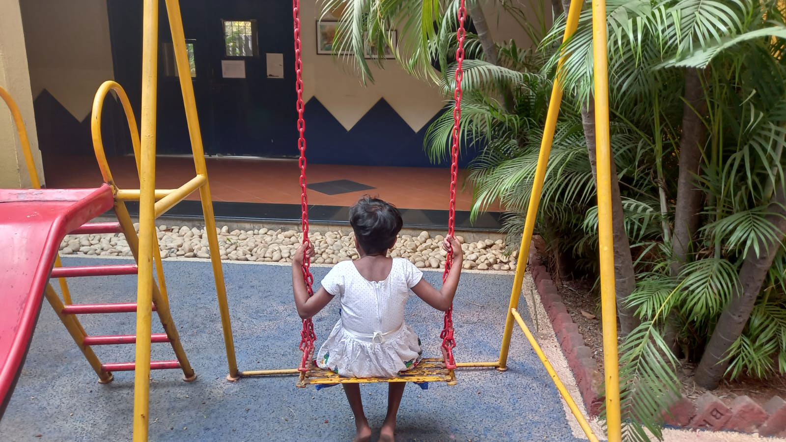 ADOPTION: Child on swing in the ground floor play area at our child care centre